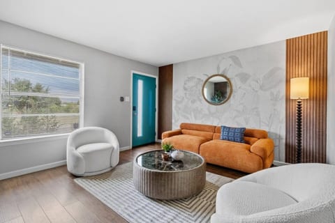 Designer living room with an orange velvet sofa and statement wallpaper