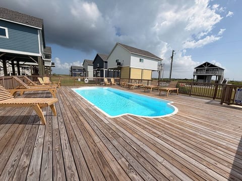 Community pool with a big sundeck and loungers