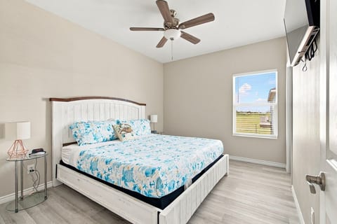 King bedroom with a wall TV and coastal bedding