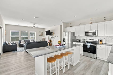White kitchen with a granite island and bar stools