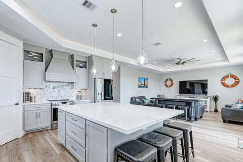 Kitchen with a quartz island, range and bar stools