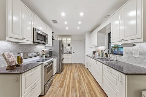 Bright chef’s galley kitchen with stainless appliances & ample workspace.