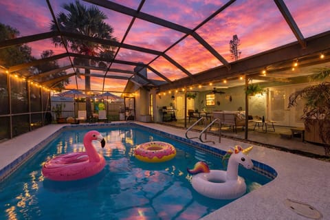 Magical screened in pool surrounded by twinkling lights and multiple seating options