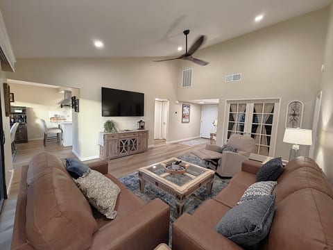 Spacious living room with brand new, cozy leather seating, La-Z-boy recliner and large screen Smart TV.
