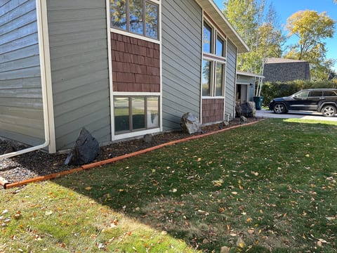 Bright exterior with large windows, lawn space, and easy driveway parking