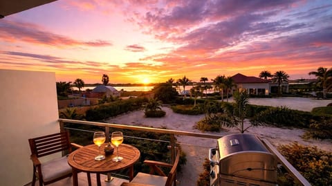 Your furnished private balcony at Gold Coast, with outdoor seating and a BBQ. Sunset colours and conditions vary.