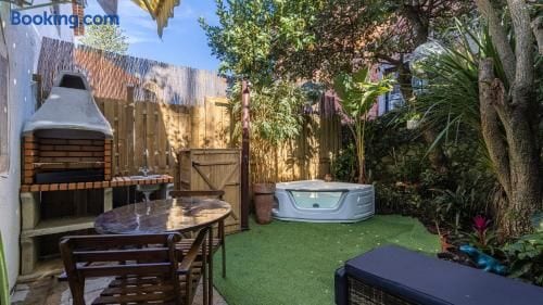 Private garden courtyard with hot tub, BBQ, and outdoor dining