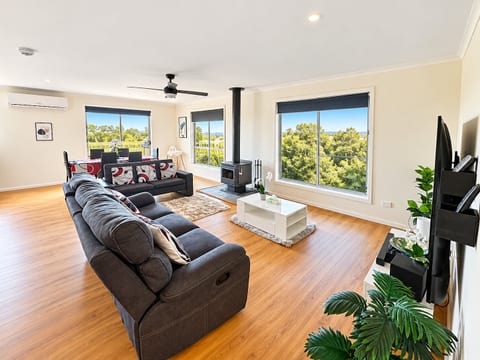 Living Room 1 : Relax and unwind at Carlenes Getaway in this light-filled open living space, featuring generous seating, a cosy fireplace and leafy views through the large windows.