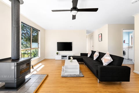 Living Room 1 : Relax in the main lounge at Carlenes Getaway, with reverse-cycle air conditioning, a ceiling fan and fireplace comfort for Loch Sport’s changing seasons