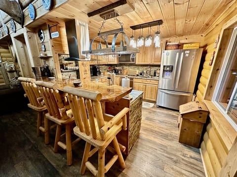 Hickory kitchen with large built-in stainless steel appliances. French door fridge with ice dispenser and filtered water. Log bar stools.