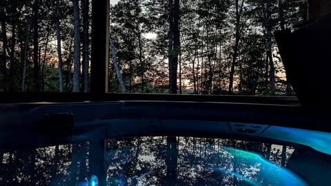 Soak in the private hot tub as the sun sets and twilight settles over the forest.