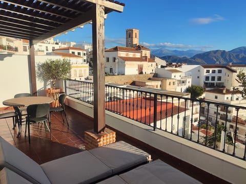 Panoramic terrace with pergola, dining table, sun loungers, gas BBQ and potted plants and views of the sea, city and mountains