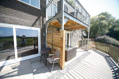 patio area in front of the two ground floor bedrroms with privacy screen and seating for two and 4 people respectively