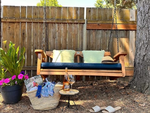 Outdoor Swing • This is a perfect place to enjoy a chilled glass of local wine • Enjoy blue skies by day or starlit skies by night • Provides  plenty of afternoon shade • Next to stacked barrels obtained from Domaine Serene • Relax and enjoy summer!