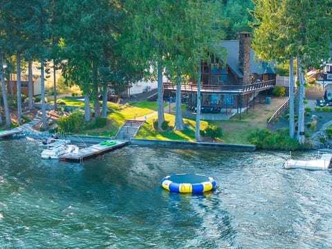 This lake house features an array of inviting spaces—from the seasonal bongo pad (May–early October) kayaks, dock, lawn, and three decks and patios, each designed for relaxation and enjoyment of the lakefront setting