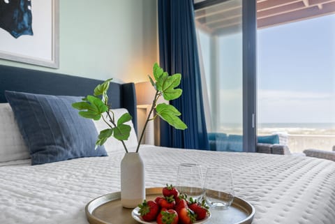 Cozy bedroom with a private ensuite and sliding glass doors opening to a spacious deck with breathtaking gulf views.