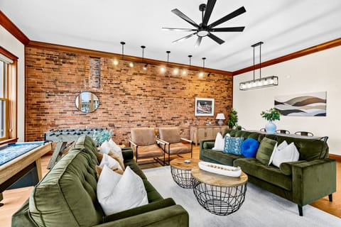 Relax in the open concept living and dining room with ample seating and beautiful original brick wall. 