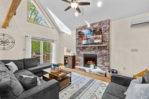 The living room space features an electric fireplace and dedicated heating and air conditioning, with convenient access to the propane grill and the porch seating area.