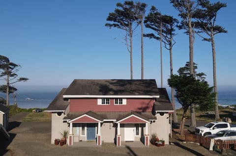 Arrive at a coastal home framed by tall trees and Pacific views.  My unit is on the left (blue door).  Parking on on the left (south side).