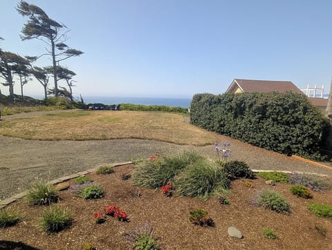 View of ocean, firepit and chairs from bedroom window