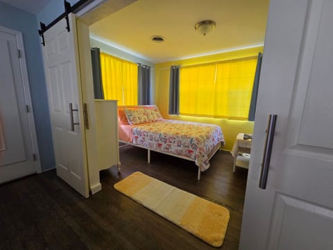 Bright, cozy bedroom with natural light and charming barn-style doors and queen size bed