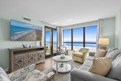 Living area features a Smart TV, ample seating, direct balcony access, and amazing Atlantic Ocean views.
