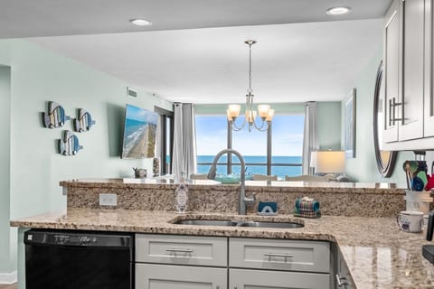 Open kitchen with granite counters overlooking the living area and sweeping Atlantic Ocean views.