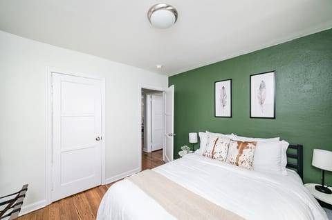 Queen bed, luggage bench, TV, and closet with hangers and shelving. Family-friendly touches include a pack-and-play and high chair stored in the closet.