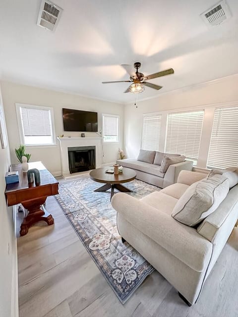 Unwind in this airy, sunlit living room with comfy seating, a smart TV over the fireplace, and stylish decor. Perfect for relaxing after a day out!
