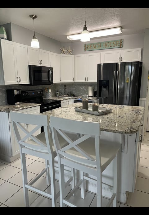 Kitchen with seating for 4 at the granite island. Plenty of dishes, glasses, flatware and cookware are provided.