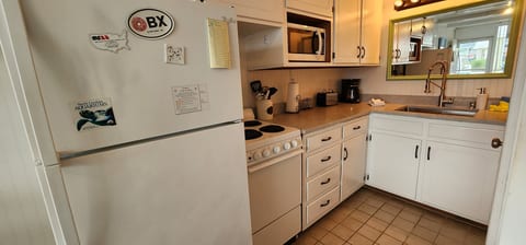 Bright, fully equipped kitchen with coffee maker and clean white cabinetry