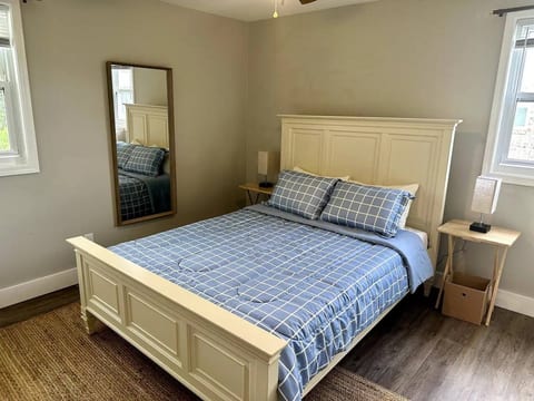 Queen-sized bed, side bed lamps, and full body mirror.
