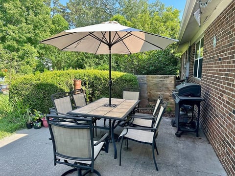 Backyard with table and barbecue grill.