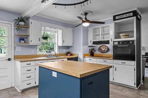 A fully equipped kitchen with stainless steel appliances, a toaster, microwave, blender, and coffee maker.