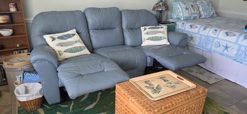 Cozy coastal lounge with recliners, nautical decor, and extra sleeping space