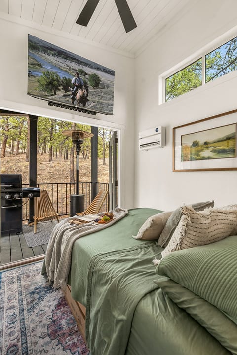 Queue up a show, sink into the pillows, and let the private deck door stay open to the pines — this room does double duty as a den.