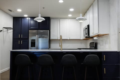 Modern navy-and-white kitchen with island seating for four and sleek finishes