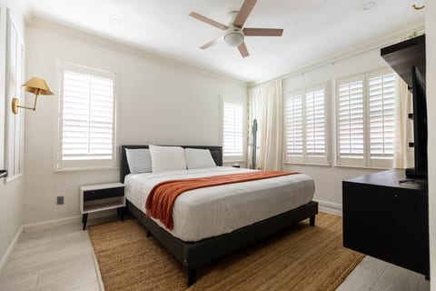 Bright, stylish bedroom with plantation shutters and cozy modern touches