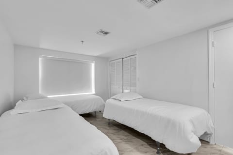 Bright triple-twin bedroom with blackout shades and closet storage