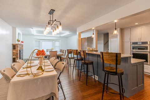 Spacious dining area with island seating, double ovens, and warm style