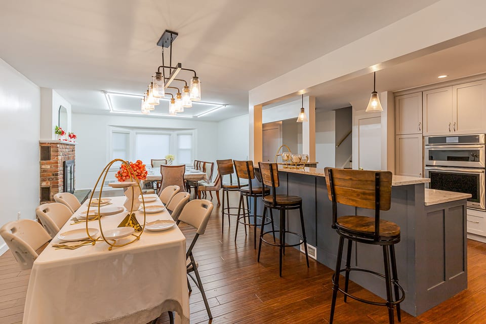 Spacious dining area with island seating, double ovens, and warm style