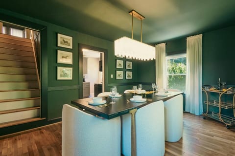 Dining Room: A stylish retreat with a dramatic chandelier and vibrant green walls for unforgettable meals!
