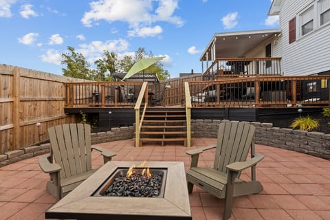 Tiered backyard retreat with fire pit, deck seating, and fenced privacy