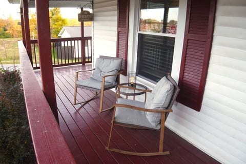 The charming front porch invites you to relax in the cozy rocking chairs, creating an idyllic setting to unwind and take in the surroundings.