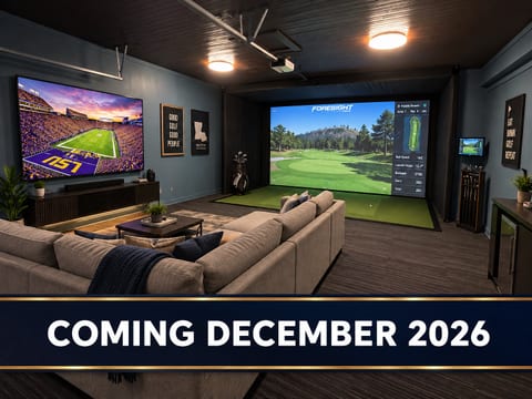 Private golf simulator lounge with big-screen TV and cozy sectional seating