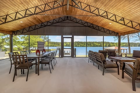Screened lakefront pavilion with dining, lounge seating, and serene views