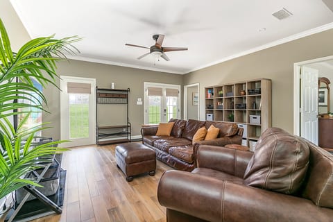 Bright, spacious living room with leather seating and abundant natural light