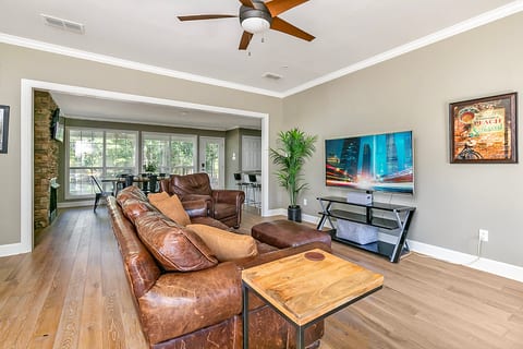 Bright open living room with leather seating and sunny dining area