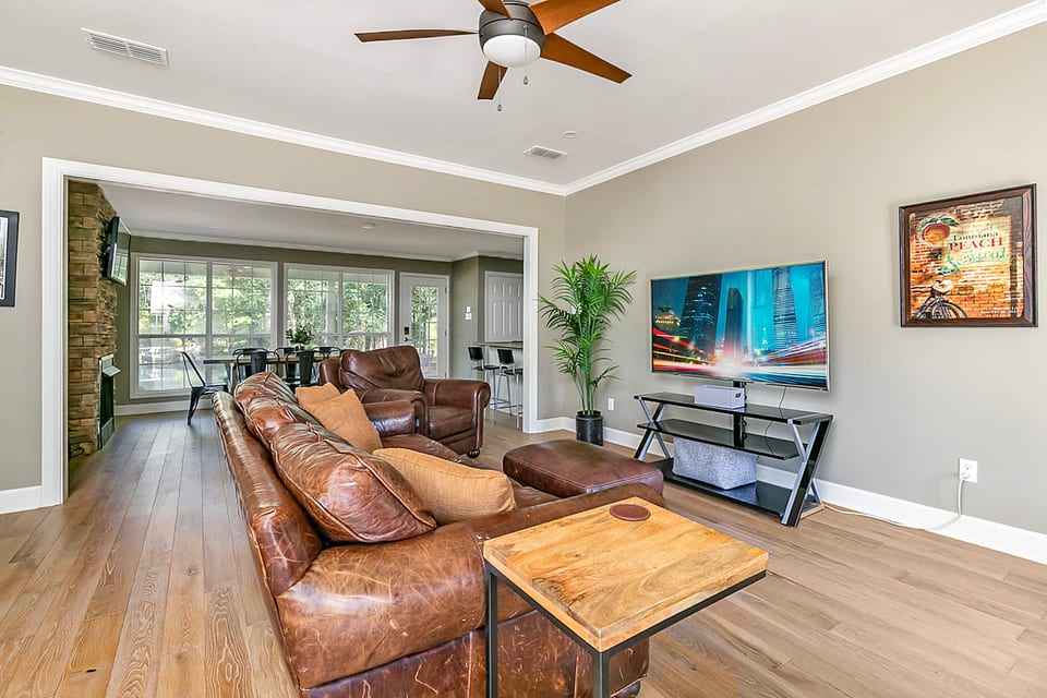 Bright open living room with leather seating and sunny dining area