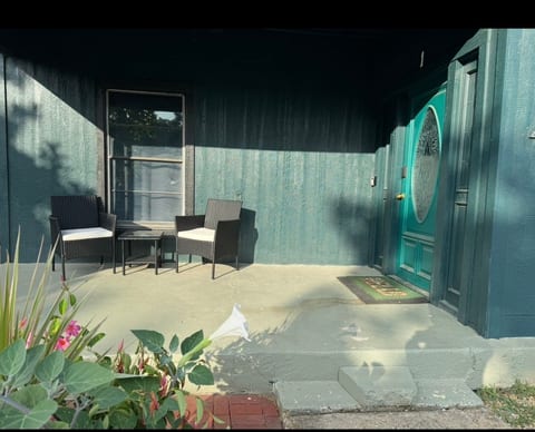Welcoming covered porch with stylish seating and a bold teal entry